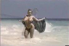 Danni Ashe posing in the waves GIF